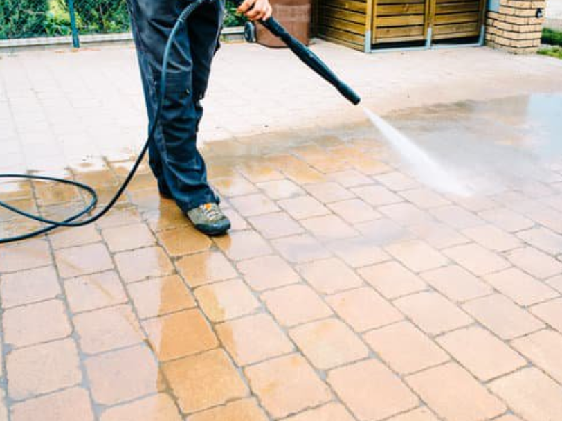 worker-jet-washing-brick-patio-pavers